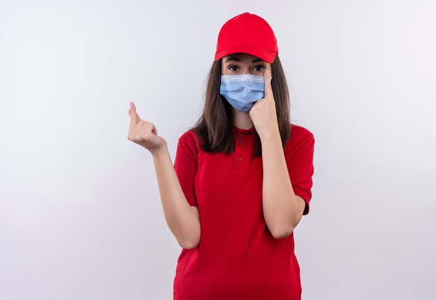 Jovem entregadora de camiseta vermelha com boné vermelho e máscara no rosto pede uma dica sobre fundo branco isolado