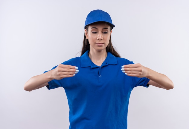 Jovem entregadora de uniforme azul e boné parecendo confiante gesticulando com as mãos, conceito de linguagem corporal