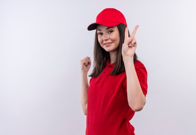 Jovem entregadora vestindo camiseta vermelha com boné vermelho, mostrando gesto de viva em fundo branco isolado