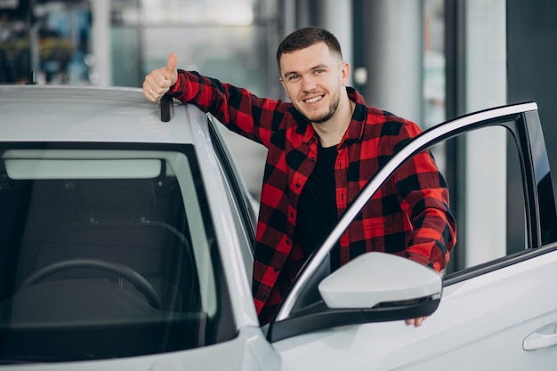 Jovem, escolhendo um carro em uma sala de exposições