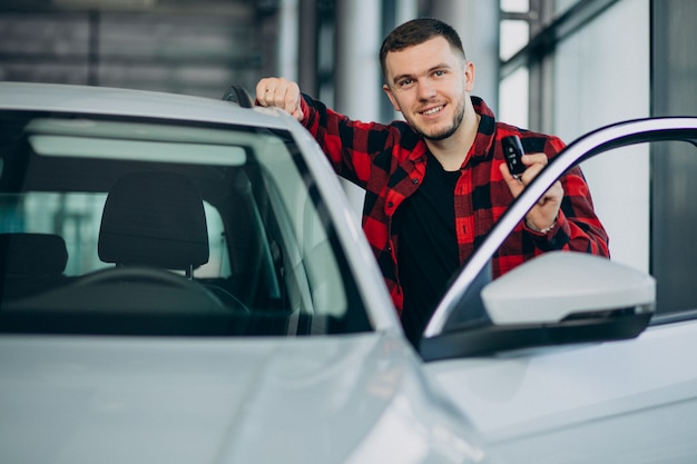 Foto grátis jovem, escolhendo um carro em uma sala de exposições