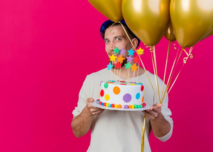 Foto grátis jovem eslavo lindo e festeiro impressionado com chapéu de festa segurando balões e um bolo de aniversário com estrelas olhando para a frente, isolado na parede rosa com espaço de cópia