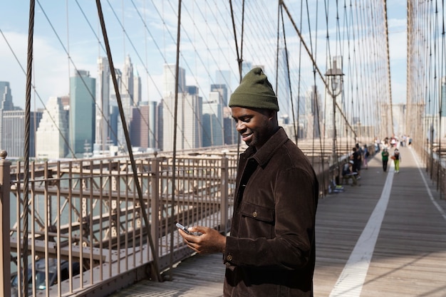 Foto grátis jovem estiloso explorando uma ponte da cidade sozinho