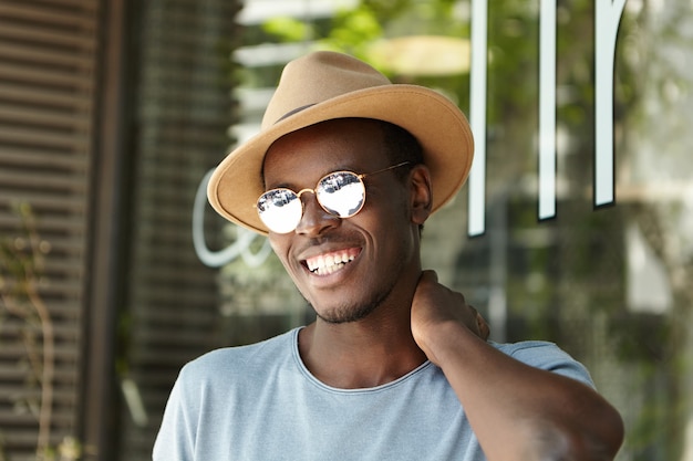 Foto grátis jovem estiloso usando chapéu e óculos escuros