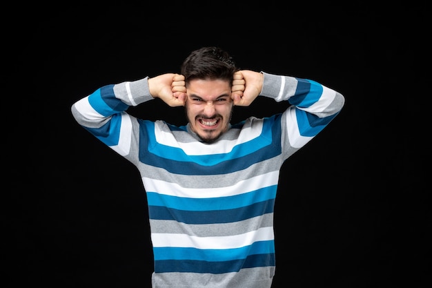 jovem estressado em camisa listrada azul com as mãos na cabeça