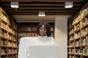 Foto grátis jovem estudante aprendendo na biblioteca