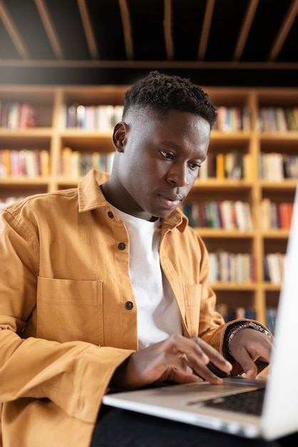 Foto grátis jovem estudante aprendendo na biblioteca