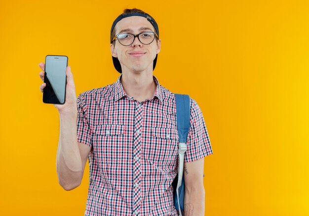 jovem estudante feliz vestindo bolsa, óculos e boné segurando o telefone