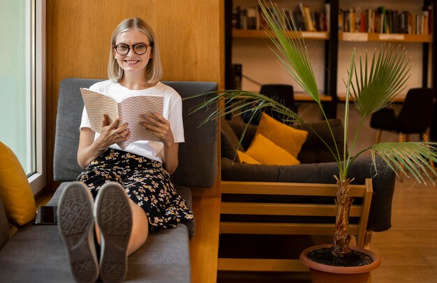 Jovem estudante lendo um livro na biblioteca