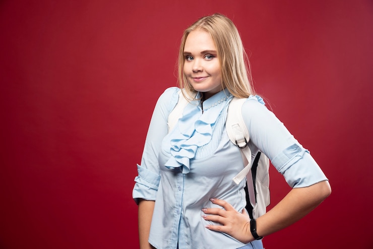 Foto grátis jovem estudante loira com sua mochila volta para a escola e se sente linda e feliz.
