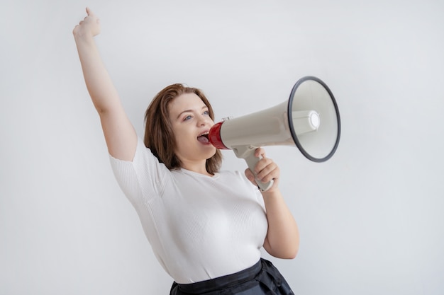 Jovem excitada feliz levantando o braço e gritando no megafone