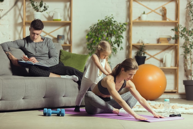 Jovem exercitando ioga aeróbica fitness em casa estilo de vida esportivo Ficando ativo durante a quarentena de bloqueio Academia em casa