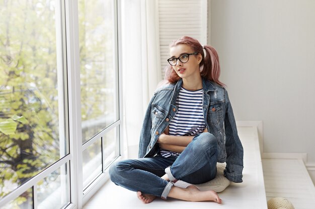 Jovem expressiva posando em um ambiente fechado