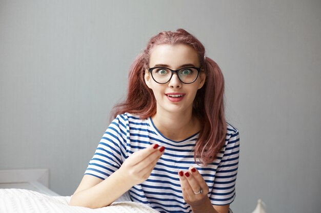 Jovem expressiva posando em um ambiente fechado