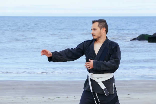 Jovem fazendo artes marciais isoladas na praia