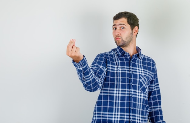 Jovem fazendo gesto italiano com os dedos em uma camisa xadrez