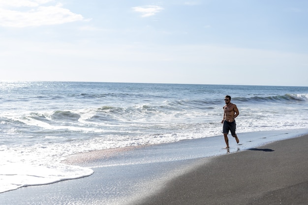 Jovem fazendo um treino de corrida na praia