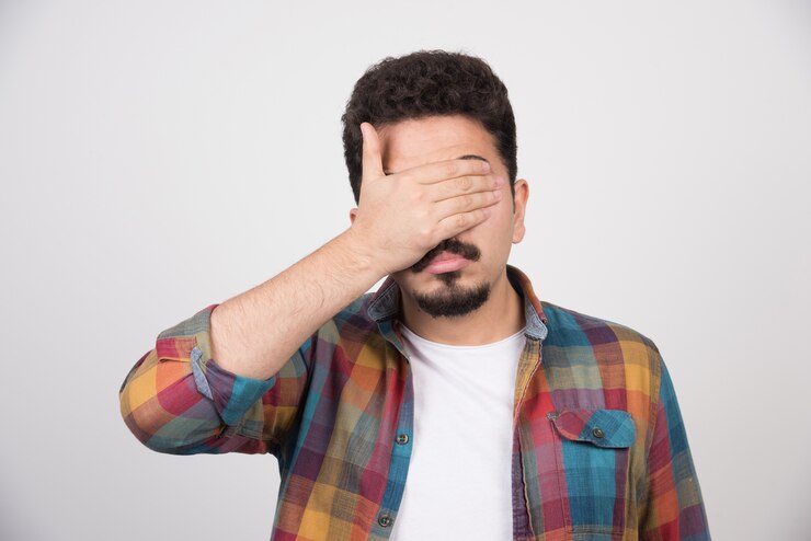 Foto grátis jovem fechando os olhos com as mãos.