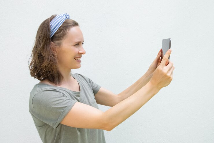 Foto grátis jovem feliz com tablet tirando fotos