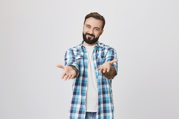 Foto grátis jovem feliz e amigável apontando as mãos para você satisfeito