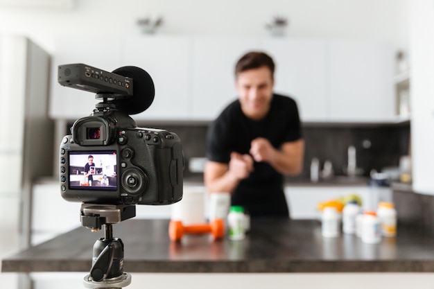 Foto grátis jovem feliz filmando seu episódio de blog de vídeo