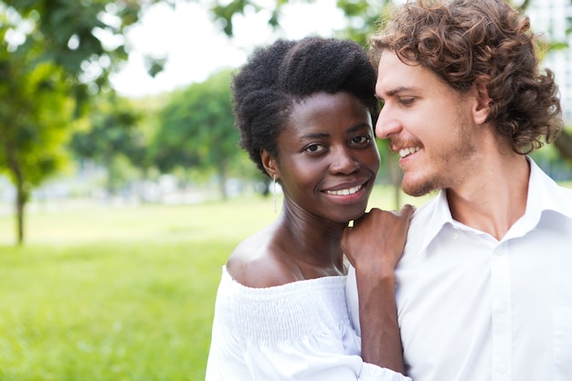 Jovem feliz olhando para sua namorada ao ar livre