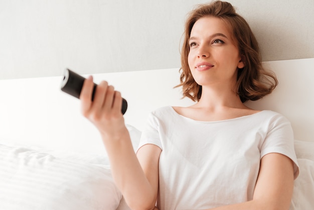 Jovem feliz sentado dentro de casa em casa assistir tv