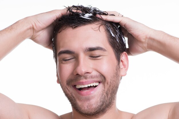 Foto grátis jovem feliz sorridente lavando o cabelo com os olhos fechados - isolado no branco.