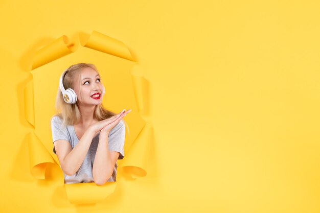 Jovem fêmea em fones de ouvido na mesa amarela som áudio de música de ultrassom