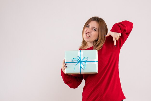 Jovem fêmea em pé com um presente de natal de frente