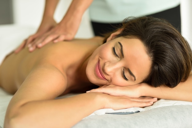 Jovem fêmea que recebe uma relaxante massagem nas costas em um centro de spa.