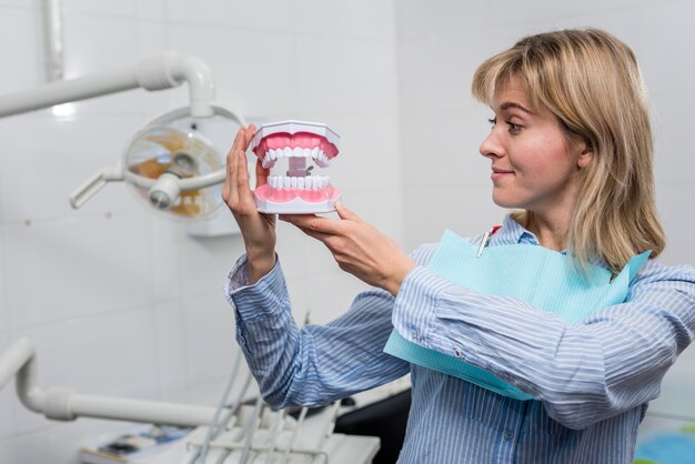 Jovem fêmea segurando os dentes de brinquedo