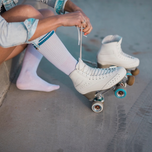 Jovem, femininas, patinador, amarrando, a, renda, de, patim rolo