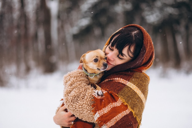 Jovem fora do parque com seu cachorrinho no inverno