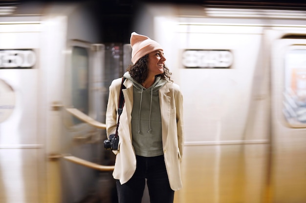 Foto grátis jovem fotógrafa estilosa explorando o metrô da cidade