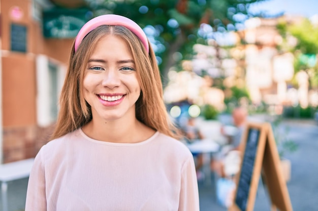 Foto grátis jovem garota caucasiana sorrindo feliz andando na cidade