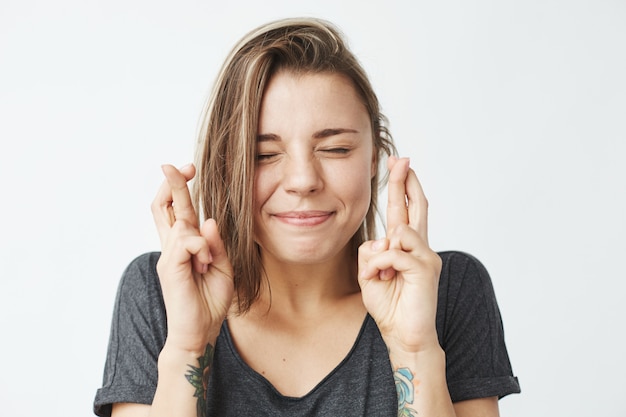 Foto grátis jovem garota emotiva bonita rezando com os olhos fechados.