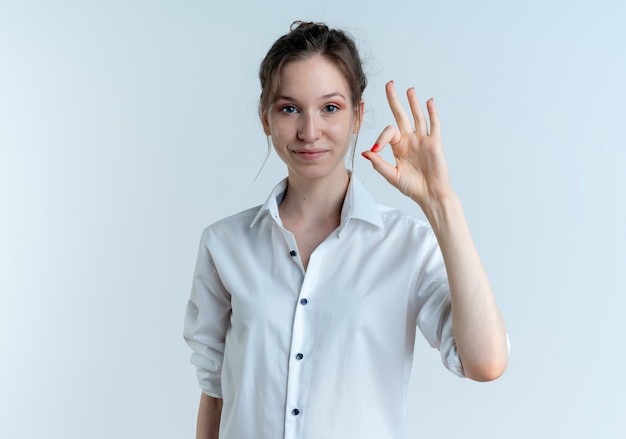 Jovem garota russa loira satisfeita gesticulando sinal de mão ok isolado no espaço em branco com espaço de cópia
