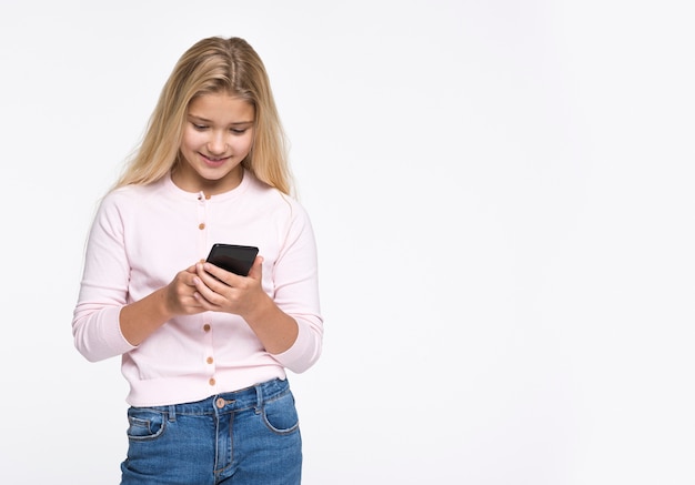 Jovem garota usando telefone com cópia-espaço
