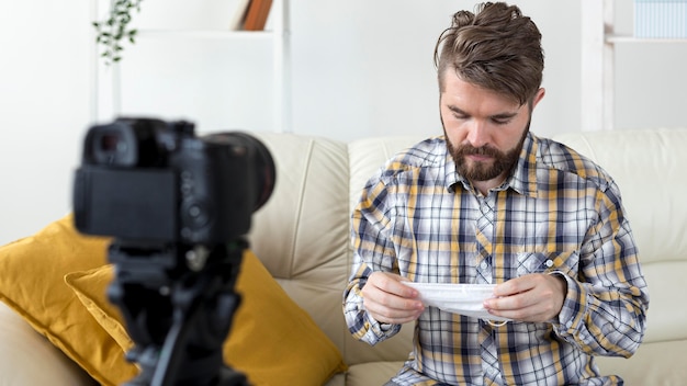 Foto grátis jovem gravando vídeo em casa com máscara facial