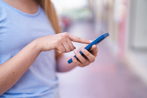 Foto grátis jovem hispânica usando smartphone na rua