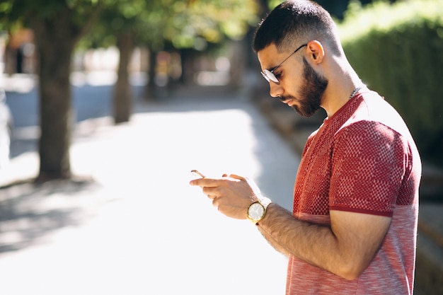 Jovem homem barbudo bonito com telefone