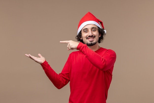 Jovem homem com uma expressão sorridente no fundo marrom emoção feriado natal
