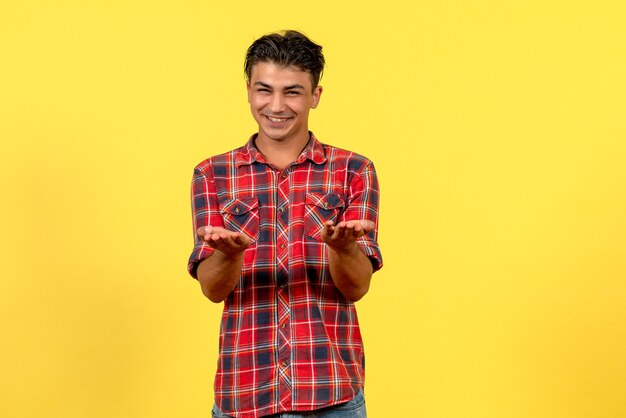 Jovem homem de camisa brilhante sorrindo de frente para o modelo masculino de cor de fundo amarelo
