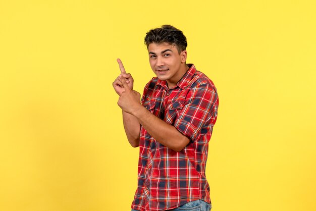 Jovem homem de camisa brilhante, vista frontal, posando no modelo masculino de cor de fundo amarelo claro
