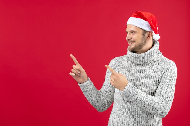 Jovem homem de camisa quente sorrindo sobre fundo vermelho de frente