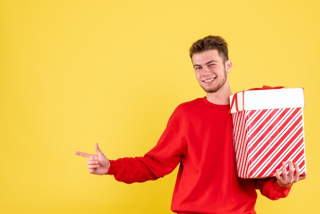 Jovem homem de camisa vermelha e presente de natal de frente