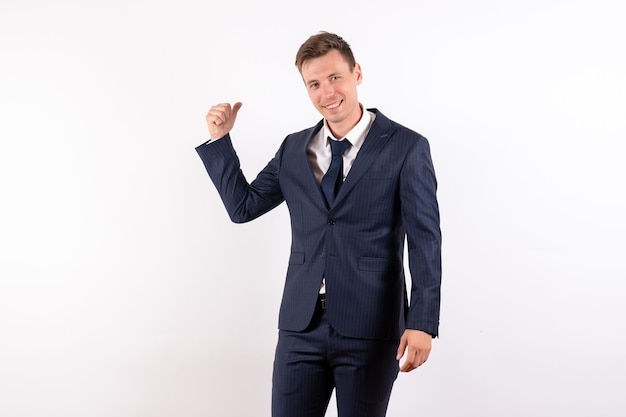 Jovem homem de frente para um elegante terno clássico sorrindo sobre fundo branco claro