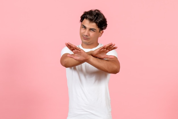 Foto grátis jovem homem de frente para uma camiseta branca em fundo rosa