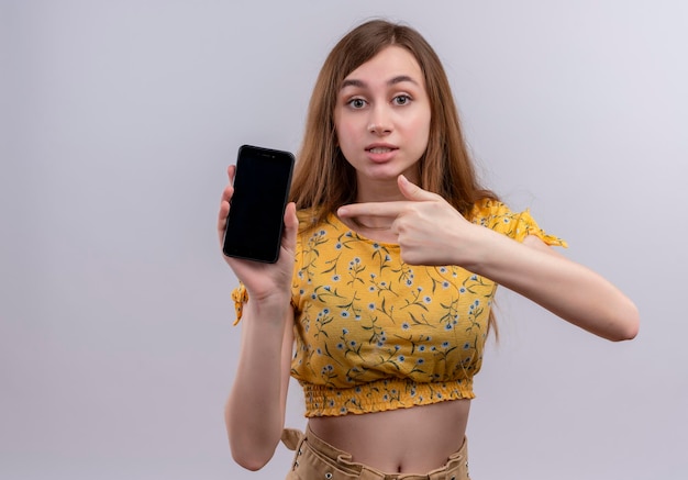 Jovem impressionada segurando um telefone celular e apontando para ele com espaço de cópia